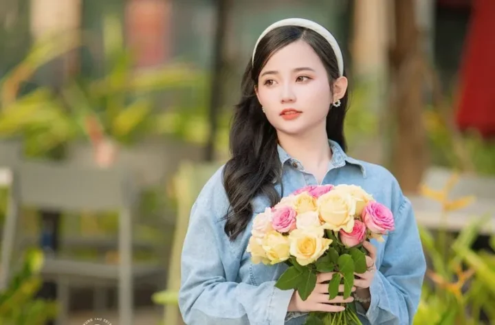 Cô gái ôm bó hoa tươi rạng rỡ giữa khung cảnh thiên nhiên